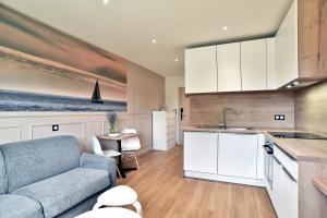 une cuisine et un salon avec un canapé et une table dans l'établissement Tom 01 - 5min à pied de la Plage, à Fréhel