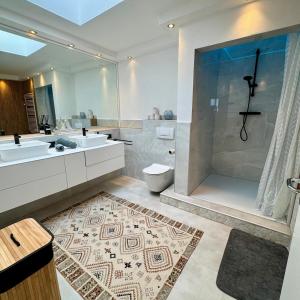 a bathroom with two sinks a toilet and a shower at Smart In Kassel - Boardinghouse in Kassel +69 photos