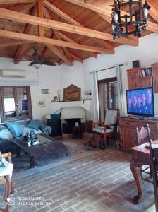 a living room with a couch and a tv at The Poros Villa in Poros