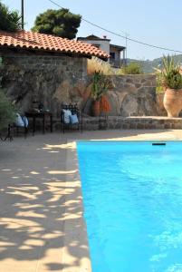 a blue swimming pool in front of a house at The Poros Villa in Poros
