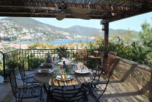 a table on a balcony with a view of the water at The Poros Villa in Poros