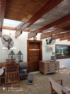 a living room with a table and chairs and wooden ceilings at The Poros Villa in Poros