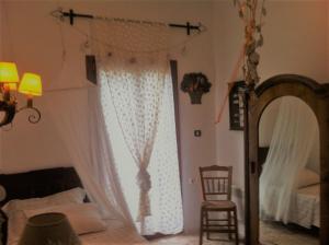 a bedroom with a bed and a mirror and a chair at The Poros Villa in Poros +19 photos