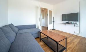 una sala de estar con un sofá y una mesa en Le Ptit Stop, en Chalon-sur-Saône