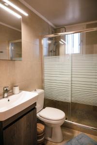 a bathroom with a toilet and a sink and a shower at Euphoria Retreat in Karfas +17 photos