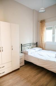 two beds in a bedroom with white cabinets and a window at Euphoria Retreat in Karfas