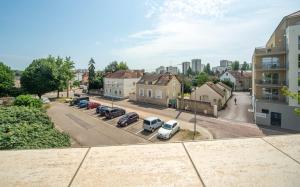 Vista aérea de una ciudad con coches aparcados en un estacionamiento. en Le Ptit Stop, en Chalon-sur-Saône