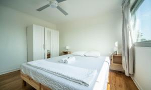 1 dormitorio blanco con 1 cama y ventilador de techo en Le Ptit Stop, en Chalon-sur-Saône