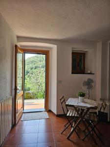 Habitación con mesa, sillas y puerta corredera de cristal. en La Lanterna, en Corniglia