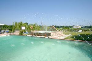 a large swimming pool with a water fountain at Kormoransee Ferien in Pucciarelli +30 photos