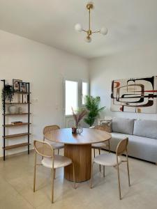 a living room with a table and chairs and a couch at Bahcé Living in Loutrá