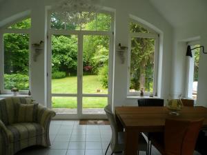 a dining room with a table and a large window at Ferienhaus In Stollhamm Mit Großem Garten in Stollhamm