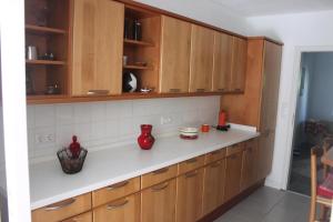 a kitchen with wooden cabinets and white counter tops at Ferienhaus In Stollhamm Mit Großem Garten in Stollhamm +12 photos