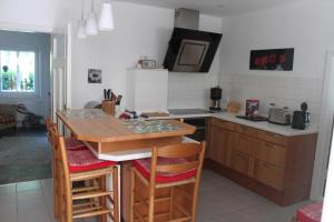 a kitchen with a table and some chairs in it at Ferienhaus In Stollhamm Mit Großem Garten in Stollhamm