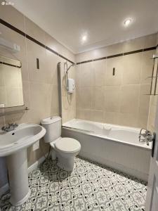 a bathroom with a toilet and a tub and a sink at Entire Cozy home 5 mins from Dublin Airport in Swords +35 photos