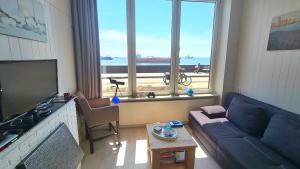 Una sala de estar con un sofá y una ventana grande. en Studio Zeezicht, en Vlissingen