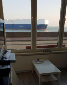 Una vista de un gran barco portacontenedores desde una ventana. en Studio Zeezicht, en Vlissingen