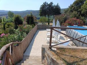 ein Resort mit einem Pool, Stühlen und einem Zaun in der Unterkunft Ferienhaus mit Privatpool für 7 Personen ca 100 m in Monteverdi Marittimo, Toskana Etruskische Küste in Monteverdi Marittimo + 32 Fotos