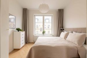 a white bedroom with a large bed and a window at Stunning Premium Apartment with Private Rooftop in Copenhagen +44 photos