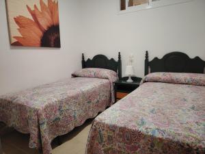 Un dormitorio con dos camas y un cuadro en la pared. en APARTAMENTO JAZMINERO, en Aguadulce