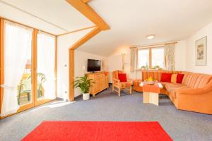 ein Wohnzimmer mit einem Sofa und einem TV in der Unterkunft "Ferienwohnung Anna" - Annehmlichkeiten von 4-Sterne Familien-und Wellnesshotel Viktoria können mitgenutzt werden in Oberstdorf