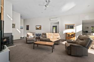 ein Wohnzimmer mit Sofas und Fernseher in der Unterkunft Hikuwai Family Retreat - Albert Town Holiday Home in Wanaka