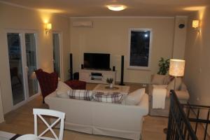 ein Wohnzimmer mit einem weißen Sofa und einem Fernseher in der Unterkunft Gemütliches Ferienhaus in Sevid mit Privatem Pool in Sevid