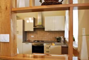 a kitchen with white cabinets and a stove top oven at Nettes Ferienhaus In Matulji Mit Eigener Terrasse in Matulji