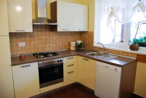 a kitchen with white cabinets and a sink and a stove at Nettes Ferienhaus In Matulji Mit Eigener Terrasse in Matulji