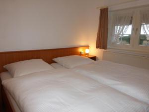 two white beds in a bedroom with a window at Ferienwohnung Mit Terrasse Im Obergeschoss in Klütz