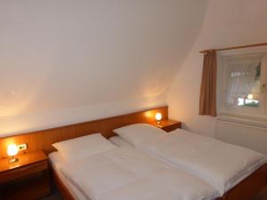 a bedroom with a bed with two white pillows at Ferienwohnung Mit Terrasse Im Obergeschoss in Klütz