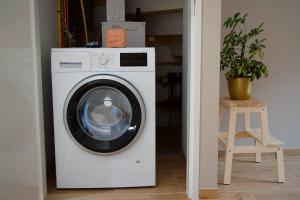 a white washing machine in a room with a plant at Vakantiehuis de Casembroot in Westkapelle