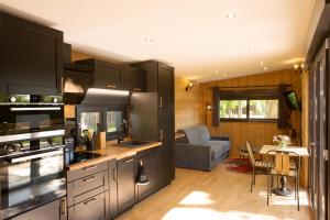 a kitchen with stainless steel appliances and a living room at Cottage Umbra Néa in Montlouis-sur-Loire