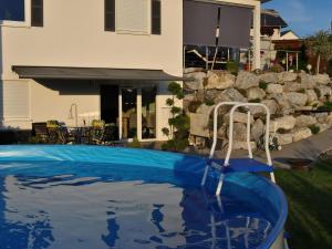 a swimming pool with a chair in a yard at Wohnung Mit Großer Gartenterrasse Und Ausblick in Argenbühl