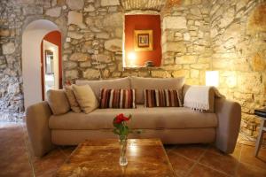 ein Wohnzimmer mit einem Sofa in einer Steinwand in der Unterkunft Ferienhaus für 3 Personen  2 Kinder ca 70 m in Preko, Dalmatien Inseln vor Zadar in Preko
