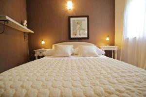 un grand lit blanc dans une chambre avec deux lumières dans l'établissement Steinhaus In Strandnähe Mit Whirlpool, à Preko 30 autres photos