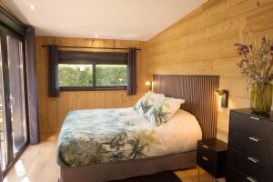 a bedroom with a bed in a room with wooden walls at Cottage Umbra Néa in Montlouis-sur-Loire +18 photos