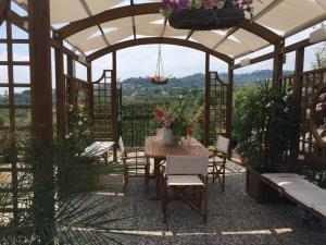 cenador con mesa, sillas y flores en Cyclops House, en Aci Catena