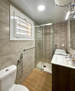 a bathroom with a toilet and a shower and a sink at Home Formentor Salou in Salou