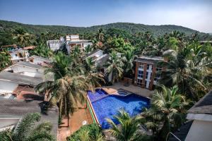 an aerial view of a resort with a swimming pool and palm trees at Royale Holiday Villa - 4BHK JAQK Holidays in Baga
