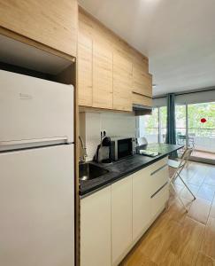 a kitchen with white cabinets and a white refrigerator at Home Formentor Salou in Salou +10 photos