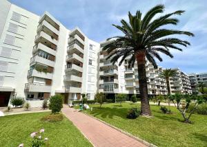 a palm tree in front of a large building at Home Formentor Salou in Salou