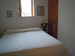 a white bed in a bedroom with a window at Appartamento C in Lipari