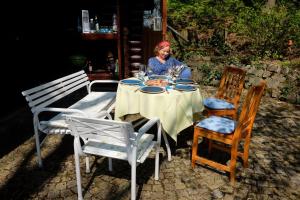 a woman sitting at a table with a plate of food at Finnisches Holzhaus in Weidenberg