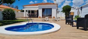 a pool in a yard with a house at Chalet Las Adelfas Chaparrillo in Conil de la Frontera