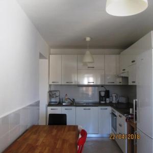 a kitchen with white cabinets and a wooden table at Ferienhaus Sara In Opatija, Kvarner Bucht in Opatija