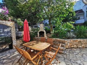 eine Terrasse mit einem Tisch, Stühlen und einem Kamin in der Unterkunft Ferienwohnung mit Balkon und Terrasse in Strandnähe in Nečujam + 30 Fotos