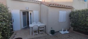 a table and chairs sitting outside of a building at à 900m de la plage sur Oléron in Dolus-d'Oléron +4 photos