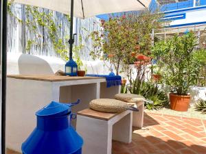 サンタ・バールバラ・デ・ネシェにあるCasa Da Aldeiaの傘の付いたテーブルの隣に置かれた青い花瓶