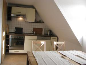 a kitchen with a stove and a table with two stools at Moderne Ferienwohnung Mitten In Greifswald in Greifswald